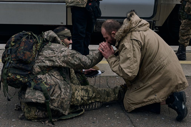 Ein Zivilist küsst die Hände eines unbekannten Soldaten am Bahnhof Kramatorsk: berührendes Foto