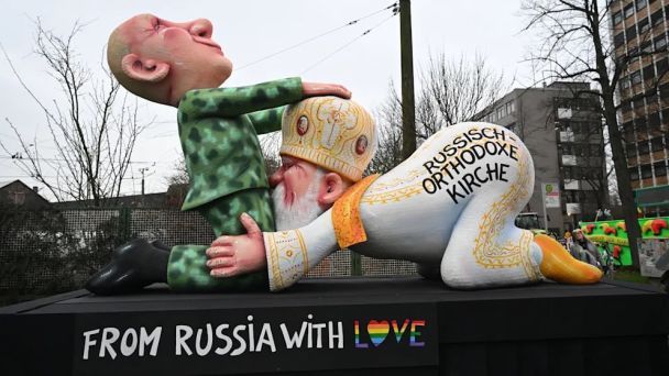 In Deutschland Patriarch Kirill und Putin wurden auf dem Karneval verspottet (Foto)“ /></p>
<p>Das Wort „Liebe“ ist in LGBT-Farben gemalt.</p>
<p>Das hat auch Bundeskanzler Olaf Scholz verstanden. Er wurde mit einem Loch im Kopf und der witzigen Überschrift „Hollaf Scholz“ dargestellt. Auf anderen Plattformen ist Adolf Hitler als Fan der rechtsextremen Alternative für Deutschland verkleidet zu sehen, und ein Hamas-Terrorist stößt eine palästinensische Familie mit der Waffe eines israelischen Panzers an.</p>
<p><img decoding=