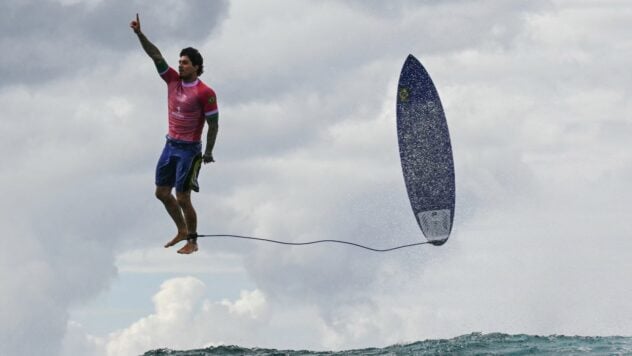 Ein Surfer mit einem in der Luft hängenden Brett: Bei den Olympischen Spielen wurde ein unglaubliches Foto aufgenommen - wie die Aufnahme ausgegangen ist